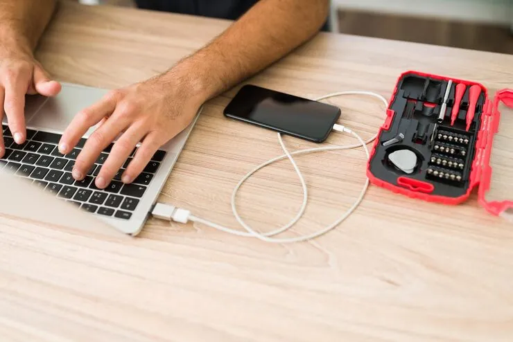 hispanic male technician typing laptop connecting smartphone computer make data backup his repair shop 662251 319 11zon