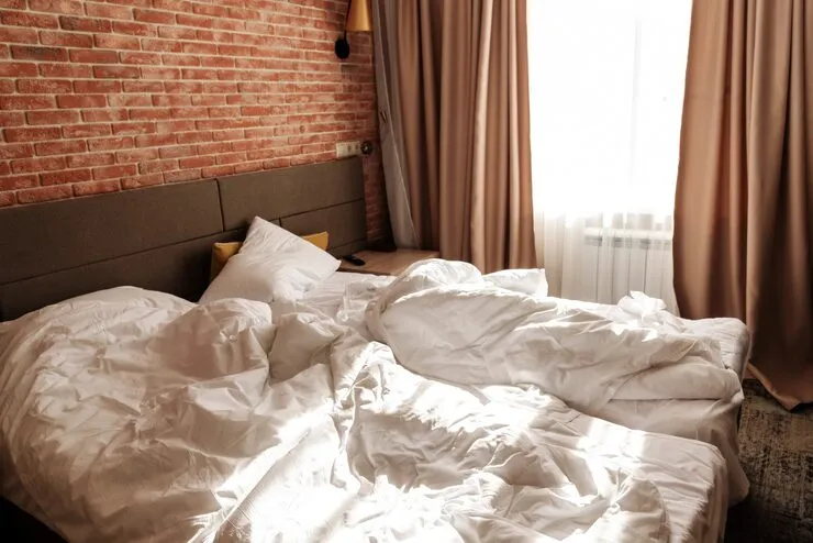 unmade two beds with white blankets pillows window loft apartment with red brick wall minimalist scandinavian style interior design spacious bedroom with furniture 119973 1170 3 11zon